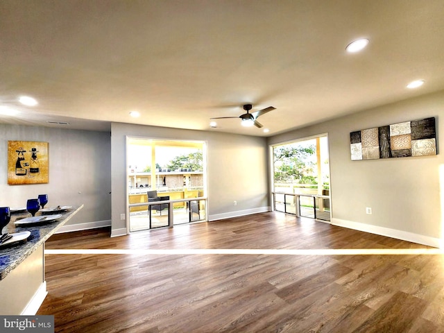 interior space with a ceiling fan, baseboards, wood finished floors, and recessed lighting