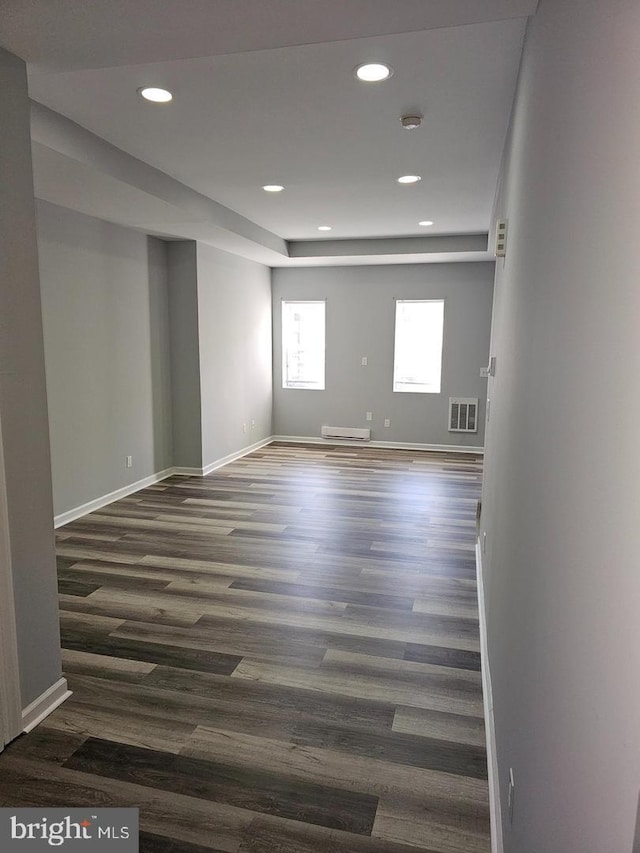 empty room featuring baseboards, visible vents, dark wood-type flooring, and recessed lighting