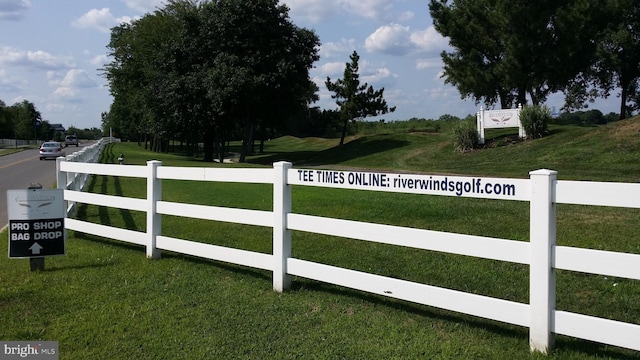 view of gate with a lawn and fence