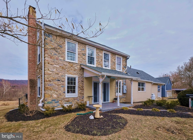 view of front facade featuring stone siding and a chimney