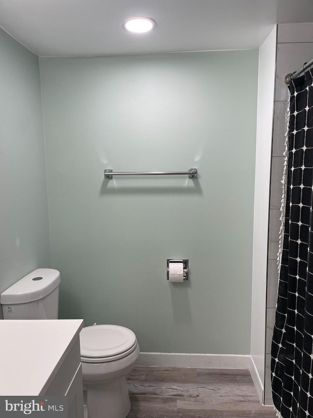 bathroom featuring wood finished floors, toilet, and baseboards