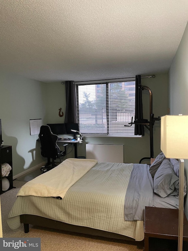 bedroom with carpet flooring, a textured ceiling, and baseboards