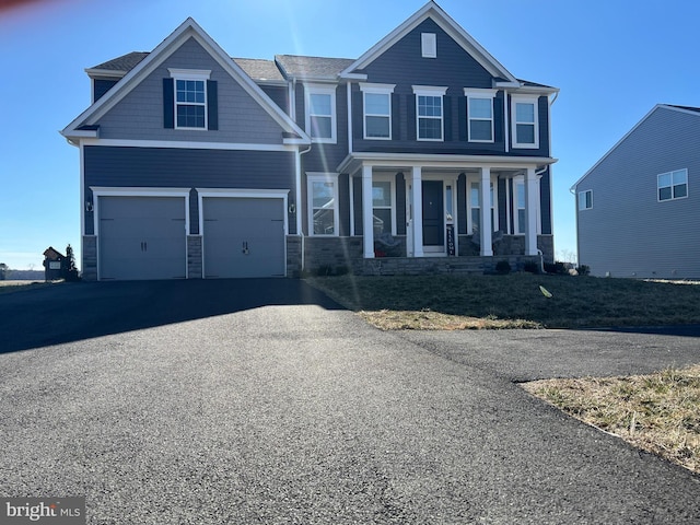 craftsman-style house featuring driveway, a garage, and a porch