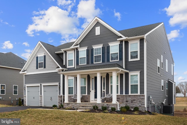 view of front of house with aphalt driveway, roof with shingles, covered porch, an attached garage, and stone siding