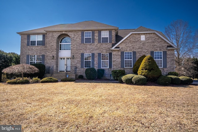 view of front facade featuring brick siding and a front lawn