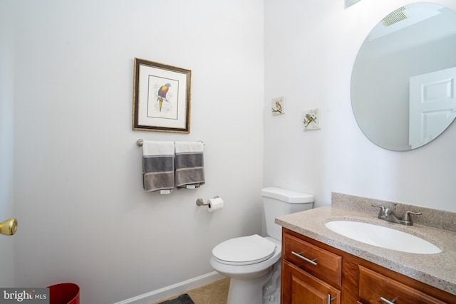 bathroom with tile patterned flooring, baseboards, vanity, and toilet