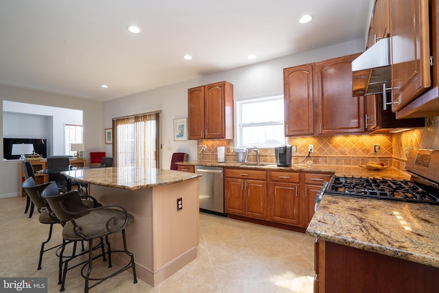 kitchen with range, a center island, dishwasher, and light stone counters