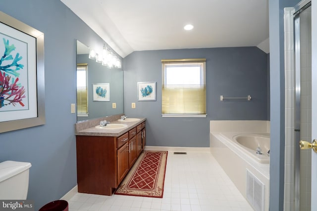 bathroom with vaulted ceiling, a garden tub, a sink, and visible vents