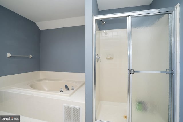 bathroom with a garden tub, visible vents, vaulted ceiling, and a stall shower