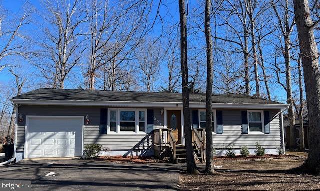 single story home featuring a garage and aphalt driveway