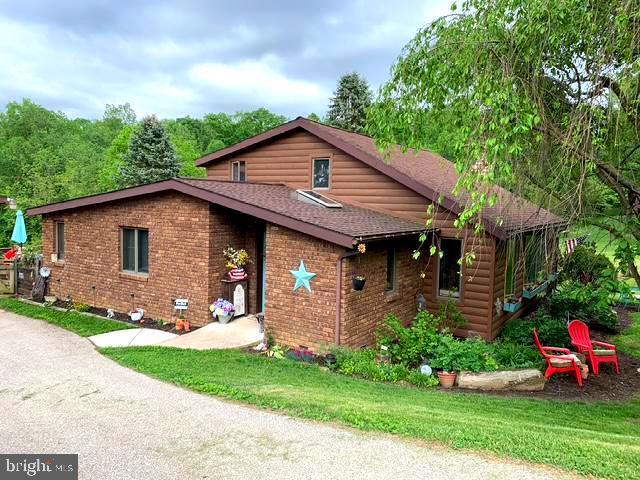 view of front facade featuring a shingled roof and brick siding