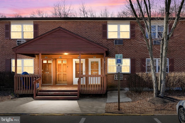 view of property with a porch and brick siding