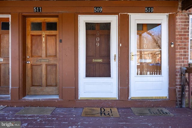 doorway to property with brick siding