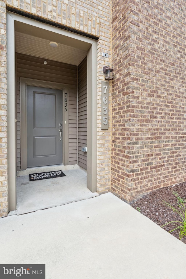 view of exterior entry with brick siding