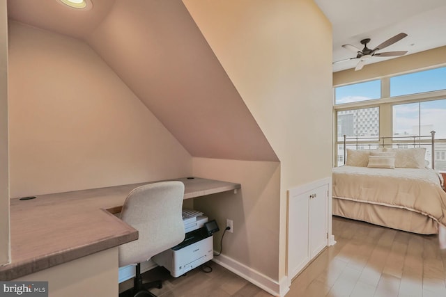 office area featuring a ceiling fan, vaulted ceiling, baseboards, and wood finished floors