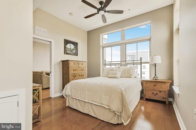 bedroom with visible vents, baseboards, and dark wood finished floors