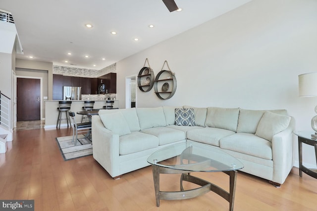 living area with light wood-style floors, baseboards, and recessed lighting