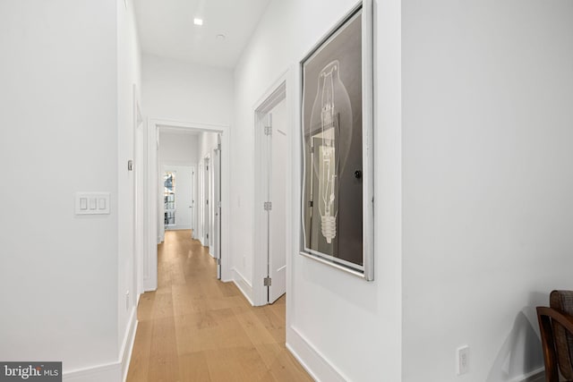 hallway with baseboards and light wood finished floors