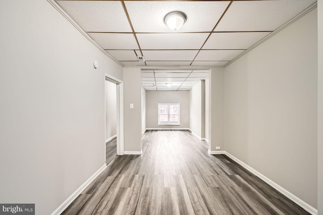 corridor featuring wood finished floors, a paneled ceiling, and baseboards