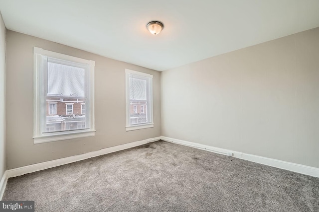 carpeted empty room with baseboards