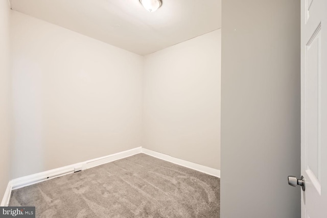 carpeted empty room featuring baseboards