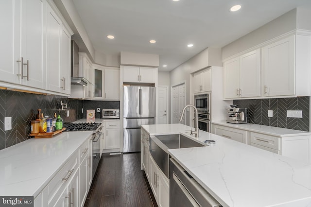 kitchen with appliances with stainless steel finishes, light stone counters, and white cabinets