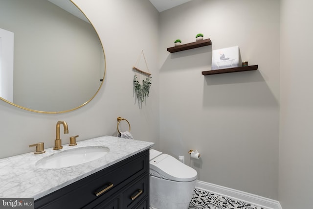 bathroom with baseboards, vanity, and toilet