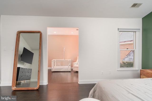 bedroom featuring baseboards, visible vents, radiator heating unit, and dark wood-type flooring