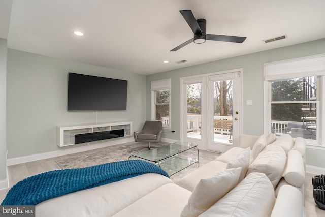 living area featuring recessed lighting, visible vents, a fireplace, and baseboards