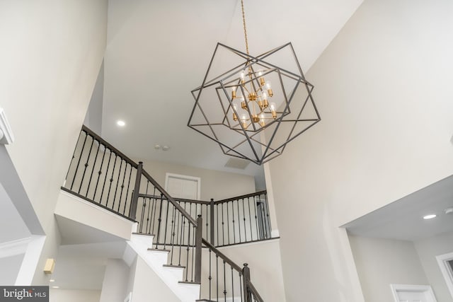 staircase featuring a chandelier and a high ceiling