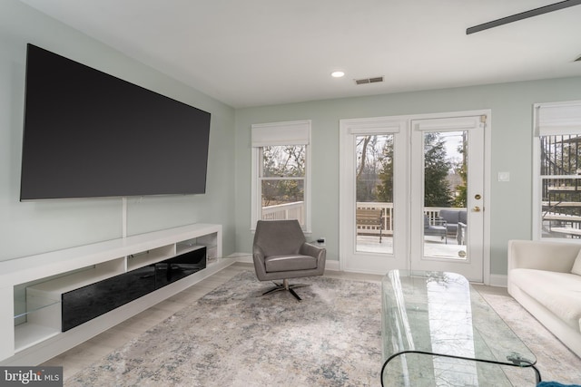 sitting room featuring light wood-type flooring, recessed lighting, visible vents, and baseboards