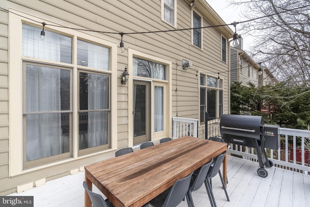 deck with a grill and outdoor dining area