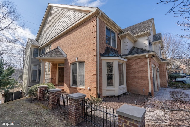 view of home's exterior featuring brick siding and fence