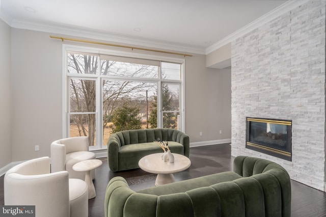 living room with ornamental molding, a stone fireplace, dark wood-type flooring, and baseboards