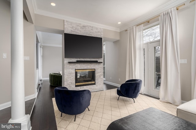 living room with a stone fireplace, baseboards, light wood-style floors, decorative columns, and crown molding