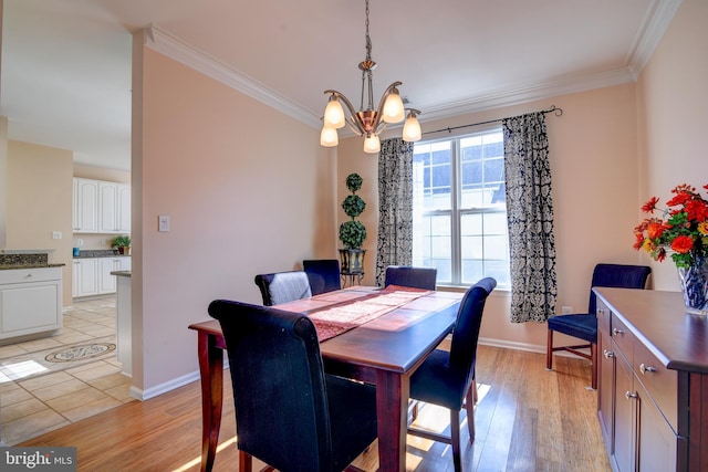 dining area with light wood finished floors, ornamental molding, and an inviting chandelier