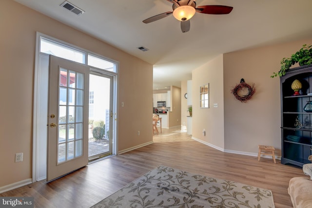 interior space with light wood-style floors, visible vents, and baseboards