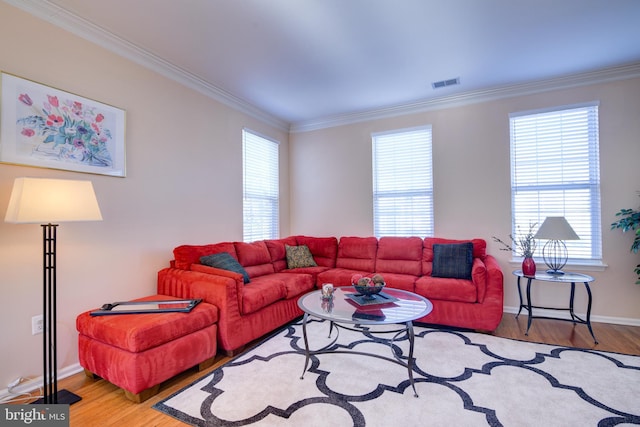 living area with visible vents, crown molding, baseboards, and wood finished floors