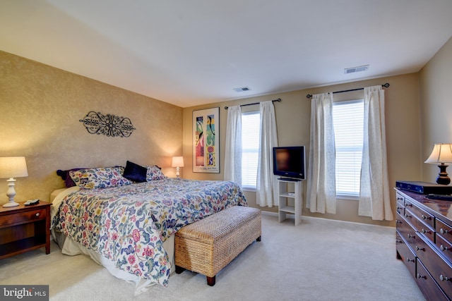 bedroom featuring baseboards, visible vents, and light colored carpet