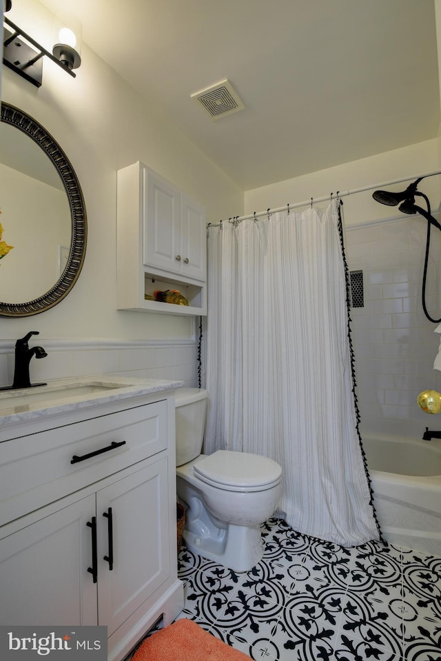 bathroom featuring shower / tub combo with curtain, visible vents, toilet, vanity, and tile patterned floors