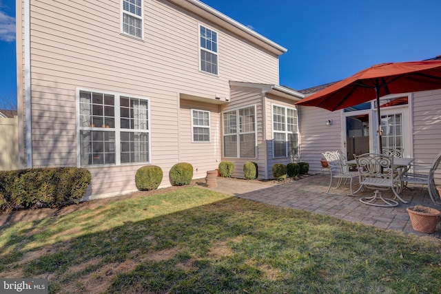 rear view of property featuring a lawn and a patio