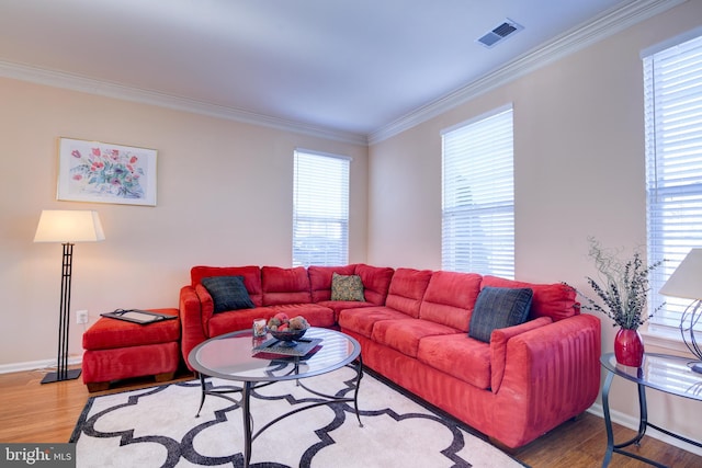 living room with ornamental molding, visible vents, baseboards, and wood finished floors