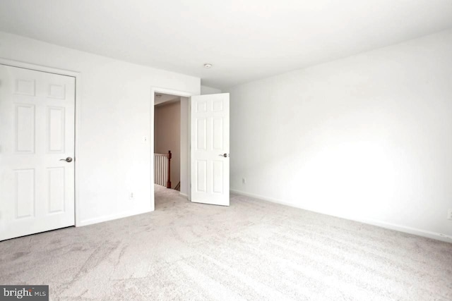 unfurnished bedroom featuring carpet floors and baseboards