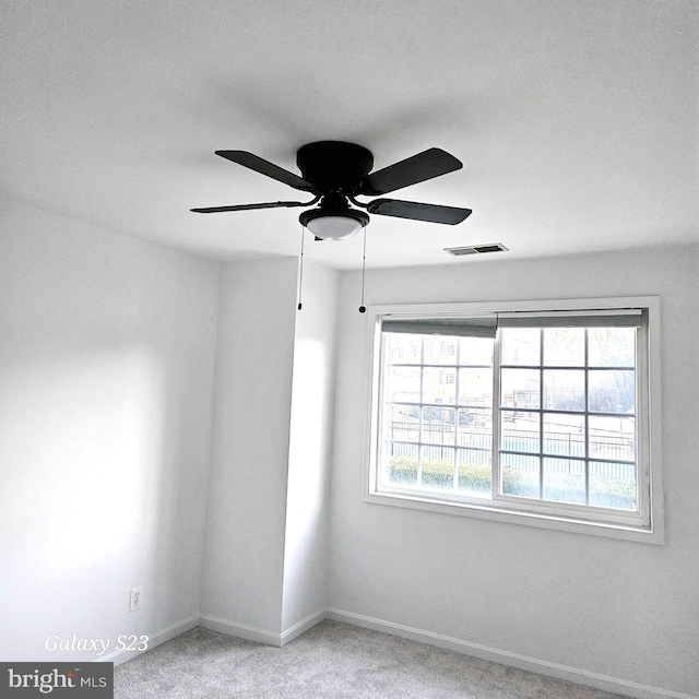 spare room with a ceiling fan, carpet flooring, visible vents, and baseboards