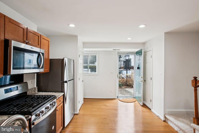 kitchen with appliances with stainless steel finishes, recessed lighting, brown cabinetry, and light wood-style floors