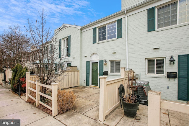 exterior space featuring brick siding and fence