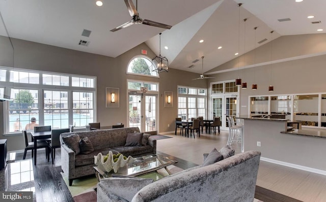 living area with high vaulted ceiling, visible vents, a ceiling fan, and french doors