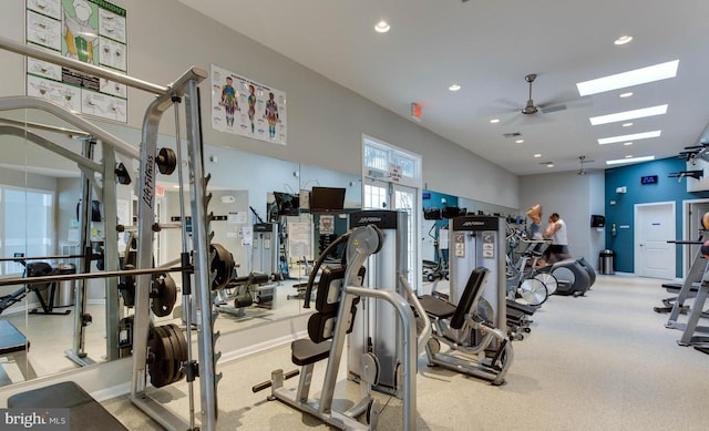 gym featuring baseboards, a skylight, a ceiling fan, and recessed lighting