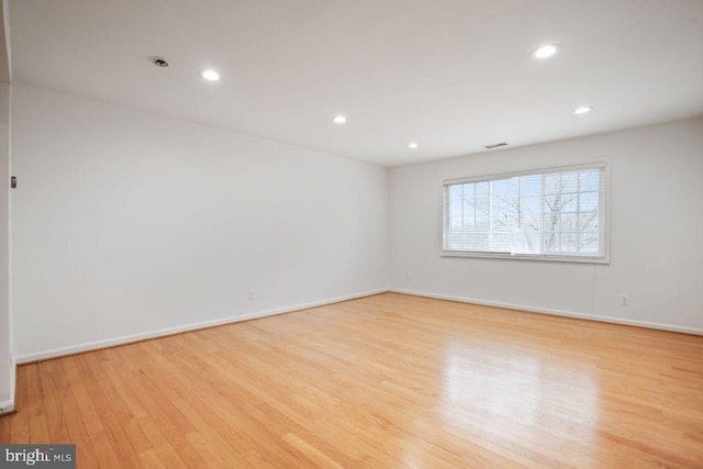 spare room featuring baseboards, wood finished floors, visible vents, and recessed lighting