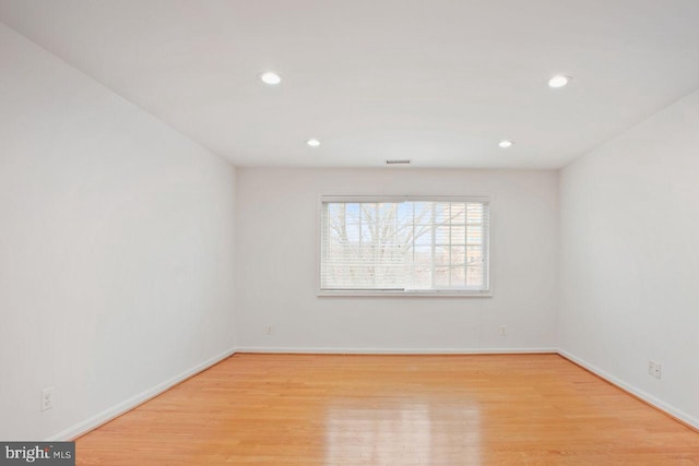 empty room with recessed lighting, light wood-type flooring, visible vents, and baseboards